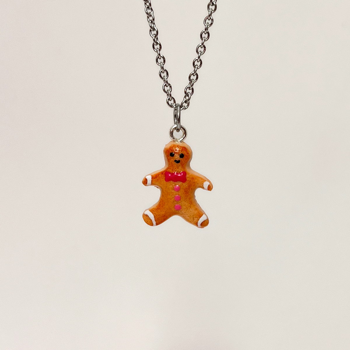 Collier - Biscuit Bonhomme pain d'épice avec noeud papillon rose